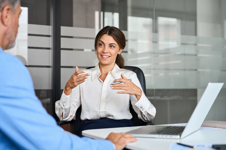 Happy female professional bank manager consulting client at office meeting